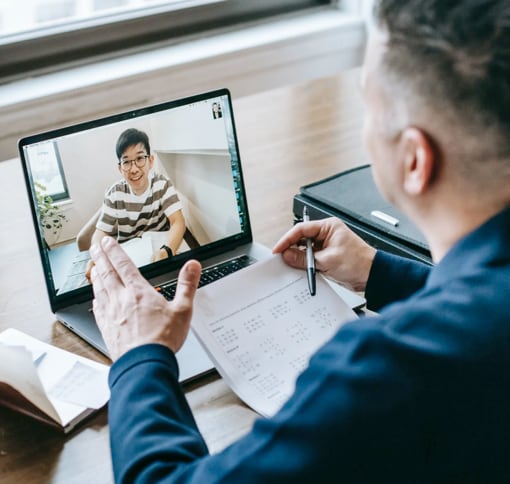 The back of a man visibly working through video conference.