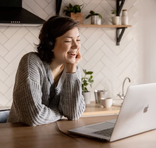 A young woman laughing while videocalling.